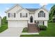 Inviting exterior of a two-story home with light siding, black shutters, a well-manicured lawn, and an attached two-car garage at 11072 Pebble Ridge Dr, Hampton, GA 30228