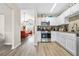 Modern kitchen featuring granite countertops, white cabinets, stainless steel appliances, and stylish laminate flooring at 11072 Pebble Ridge Dr, Hampton, GA 30228