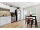 Bright eat-in kitchen boasts stainless steel appliances, white cabinets, granite countertops, and access to the backyard at 11072 Pebble Ridge Dr, Hampton, GA 30228