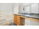 Well-lit bathroom with large tub and wooden vanity offers a relaxing space at 11072 Pebble Ridge Dr, Hampton, GA 30228
