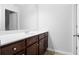 Bathroom featuring a light-colored countertop with rich wood cabinets and a large mirror at 1433 Sand Way, Lawrenceville, GA 30045
