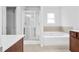 Bathroom featuring a soaking tub with tile backsplash next to a glass enclosed shower at 1433 Sand Way, Lawrenceville, GA 30045