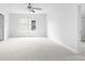 A spacious bedroom with light walls, neutral carpet, a ceiling fan, and an exterior window at 1433 Sand Way, Lawrenceville, GA 30045