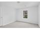A bright bedroom featuring neutral carpeting, light grey walls, and a window providing natural light at 1433 Sand Way, Lawrenceville, GA 30045