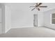 A spacious bedroom with light walls, neutral carpet, a ceiling fan, and an exterior window at 1433 Sand Way, Lawrenceville, GA 30045