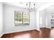 Bright dining area featuring wood floors, white walls, a chandelier and large window at 1433 Sand Way, Lawrenceville, GA 30045