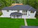 Aerial view of a modern home's backyard with covered patio, stone pathway, and lush green lawn at 2709 Collins Hill Rd, Lawrenceville, GA 30043