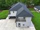 Aerial view of a modern home's backyard with a patio, balcony, and lush green lawn and modern garage at 2709 Collins Hill Rd, Lawrenceville, GA 30043