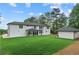 Large, well-maintained backyard featuring a covered patio area and an additional outbuilding, surrounded by trees at 2709 Collins Hill Rd, Lawrenceville, GA 30043