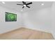 Simple bedroom with hardwood floors, a ceiling fan, and a view of trees outside the window at 2709 Collins Hill Rd, Lawrenceville, GA 30043