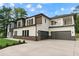 Contemporary home featuring a spacious driveway leading to a stylish two-car garage, complemented by lush landscaping at 2709 Collins Hill Rd, Lawrenceville, GA 30043