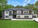 Modern two-story home with a contrasting color scheme, well-manicured lawn, and elegant front entrance at 2709 Collins Hill Rd, Lawrenceville, GA 30043