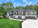 Stunning two-story home with modern design, lush lawn, and a spacious driveway leading to a two-car garage at 2709 Collins Hill Rd, Lawrenceville, GA 30043