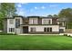Beautifully landscaped home with lush green grass, modern design, and a combination of brick, white, and wood exterior finishes at 2709 Collins Hill Rd, Lawrenceville, GA 30043