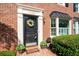 Inviting front door with wreath, set in a brick facade with manicured shrubs at 1223 Whitlock Ridge Sw Dr, Marietta, GA 30064