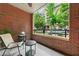 Cozy brick balcony with seating and a serene outdoor view of lush greenery at 273 12Th Ne St # 114, Atlanta, GA 30309