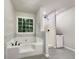 Modern bathroom featuring a soaking tub, glass-enclosed shower, and tile accents offers a spa-like experience at 339 Warrenton Dr, Douglasville, GA 30134