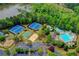 Aerial view highlighting community pool, tennis courts, and lush landscaping near lake at 3565 Hickory Branch Trl, Suwanee, GA 30024