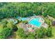 Beautiful community pool area with multiple pools, water slide, and ample lounging space surrounded by trees at 3565 Hickory Branch Trl, Suwanee, GA 30024