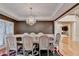 Elegant dining room with tray ceiling, chandelier, and staircase in the background at 3565 Hickory Branch Trl, Suwanee, GA 30024