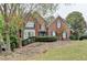 Charming two-story brick home with well-manicured landscaping, shutters, and an American flag at 3565 Hickory Branch Trl, Suwanee, GA 30024