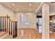 Bright foyer featuring hardwood floors, a staircase with a wooden banister, and an entry to the living area at 3565 Hickory Branch Trl, Suwanee, GA 30024