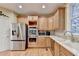 Bright kitchen features stainless steel appliances, wooden cabinets, and hardwood floors at 3565 Hickory Branch Trl, Suwanee, GA 30024
