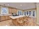 Kitchen with island, light wood cabinets, hardwood floors, barstool seating, and stainless appliances at 3565 Hickory Branch Trl, Suwanee, GA 30024