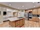 Open kitchen with stainless steel appliances, kitchen island with cooktop, and barstool seating at 3565 Hickory Branch Trl, Suwanee, GA 30024