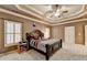 This is a well lit main bedroom with a tray ceiling, ceiling fan, large windows, and carpeted floors at 3565 Hickory Branch Trl, Suwanee, GA 30024