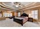 Spacious main bedroom with a tray ceiling, fan, sitting area, and large windows bringing in natural light at 3565 Hickory Branch Trl, Suwanee, GA 30024