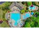 Aerial shot of a pool, kiddie area, splash pad, and slide surrounded by lush landscaping at 3565 Hickory Branch Trl, Suwanee, GA 30024