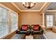 This sitting area features a window, ceiling fan, carpeted floors and two comfortable leather arm chairs at 3565 Hickory Branch Trl, Suwanee, GA 30024