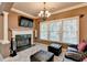 A bright sitting room featuring a fireplace, ceiling fan, and large windows for ample natural light at 3565 Hickory Branch Trl, Suwanee, GA 30024