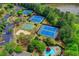 Aerial view of the community's multiple tennis courts, sand volleyball, and pool near a lake at 3565 Hickory Branch Trl, Suwanee, GA 30024