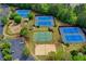Aerial view of community tennis courts, playground, and sand volleyball court with landscaping at 3565 Hickory Branch Trl, Suwanee, GA 30024