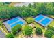 Aerial view of community tennis courts, perfect for sports enthusiasts, surrounded by trees and greenery at 3565 Hickory Branch Trl, Suwanee, GA 30024