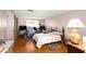 A bright bedroom with a decorative wrought iron bed frame, a window for natural light, and wood floors at 4256 Village Square Ln, Stone Mountain, GA 30083