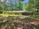 One-story brick home on a large lot with mature trees, exuding a natural charm at 225 Oglesby Bridge Rd Se, Conyers, GA 30094