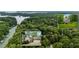 Stunning aerial view of a lakeside home nestled amongst lush greenery, boasting an attached garage at 2709 Windrush Dr, Buford, GA 30518