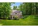 Beautiful backyard with mature trees, a green lawn, and a view of the home at 2709 Windrush Dr, Buford, GA 30518