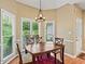 Bright breakfast nook featuring a wood table, chandelier, and large windows showcasing the outdoor view at 2709 Windrush Dr, Buford, GA 30518
