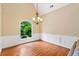 Dining room featuring hardwood floors, wainscoting, a chandelier, and a large arched window at 2709 Windrush Dr, Buford, GA 30518