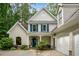 Charming two-story home featuring blue shutters, white siding, and an attached two car garage at 2709 Windrush Dr, Buford, GA 30518