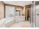 Relaxing main bathroom featuring a soaking tub, a glass enclosed shower, and dual vanities at 2709 Windrush Dr, Buford, GA 30518