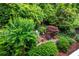 Inviting backyard featuring mature trees, flowering plants, and stone accents at 3833 Savannah E Sq, Atlanta, GA 30340