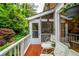Charming screened porch with outdoor seating, white railing, and views of lush greenery at 3833 Savannah E Sq, Atlanta, GA 30340