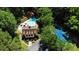 Aerial view of community clubhouse with a pool and a tennis court, surrounded by lush greenery and trees at 3837 Fenway Xing, Marietta, GA 30062