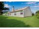 Backyard showcasing a home's neutral siding, well-maintained lawn, and trimmed landscaping at 424 Yellow River Walk, Lawrenceville, GA 30043
