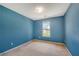 Carpeted bedroom featuring a window offering outdoor views and blue painted walls at 424 Yellow River Walk, Lawrenceville, GA 30043